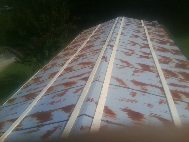 Rusted metal roof panels with new wood purlins before replacement — Storm Damage Roof Repair in Walnut Cove by Roofing Brothers
