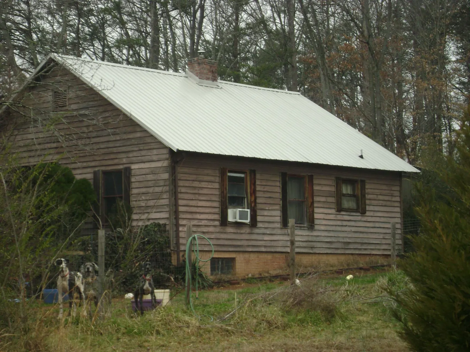 White metal roof on an old wood sided farmhouse, from a Metal Roof Installation job in Walnut Cove